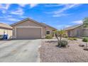 Exterior of tan house with a two car garage and desert landscaping at 12605 W Dreyfus Dr, El Mirage, AZ 85335