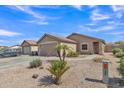 Exterior view of a tan home with desert landscaping, two car garage, and walkway to the front door at 12605 W Dreyfus Dr, El Mirage, AZ 85335