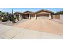 Attractive single-story home featuring a large driveway, a three-car garage, and desert-friendly landscaping at 13458 W Coronado Rd, Goodyear, AZ 85395