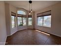 Sunlit dining area featuring tile flooring, multiple windows, and a modern pendant light fixture at 1424 W Mead Dr, Chandler, AZ 85248