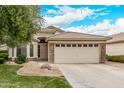 Inviting home featuring a well-kept lawn, stone accents, and a spacious two-car garage at 1424 W Mead Dr, Chandler, AZ 85248