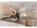Open kitchen with oak cabinets, black appliances, and a breakfast bar overlooking the living area at 1424 W Mead Dr, Chandler, AZ 85248