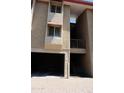 View of the home's covered parking, stairs to upper units, and neutral exterior color scheme at 151 E Broadway Rd # 206, Tempe, AZ 85282