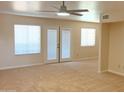 Bright living room with neutral carpet, ceiling fan, and french doors leading to outdoor balcony at 151 E Broadway Rd # 206, Tempe, AZ 85282