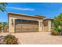 Two-car garage of a home with a low-pitched roof and desert landscaping at 1804 E Sattoo Way, Queen Creek, AZ 85140