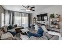 Comfortable living room showcasing a large sectional sofa, decorative pillows, a ceiling fan, and a modern entertainment center at 20142 N 260Th Dr, Buckeye, AZ 85396