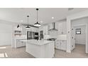 Spacious kitchen with white cabinets, a large island and stainless steel appliances at 20308 W Roma Ave, Buckeye, AZ 85396