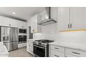 Bright kitchen featuring white cabinets, stainless steel appliances and subway tile backsplash at 20308 W Roma Ave, Buckeye, AZ 85396