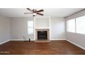 Bright and spacious living room featuring hard wood floors, a fan and a cozy fireplace at 2040 S Longmore St # 7, Mesa, AZ 85202
