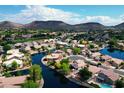 Aerial view showcasing a beautiful neighborhood with lakes, lush landscaping, and mountain views at 20740 N 62Nd Ave, Glendale, AZ 85308