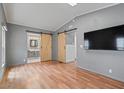 Contemporary bedroom featuring barn doors, gray walls, and wood-look floors at 2121 N Center St # 166, Mesa, AZ 85201