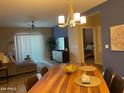 Spacious dining area showcasing a wooden table, stylish lighting, and seamless flow to the living space at 2511 W Queen Creek Rd # 244, Chandler, AZ 85248