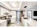 Well-lit kitchen features stainless steel appliances, white cabinets, and a stylish tile backsplash at 2609 N Pleasant Dr, Chandler, AZ 85225