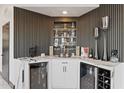 Elegant bar area with wine coolers, display shelving, and modern countertops at 27 W Cochise Dr, Phoenix, AZ 85021