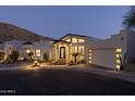 Stunning exterior of the home with a well-manicured yard and accent lighting at dusk at 27 W Cochise Dr, Phoenix, AZ 85021