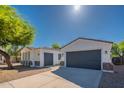 Home exterior featuring attached garages, stucco walls, and desert landscaping at 2991 E Folley Pl, Chandler, AZ 85225
