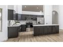 Bright kitchen featuring stainless steel appliances, dark cabinets, and an island with a white countertop at 3022 E Emile Zola Ave, Phoenix, AZ 85032