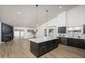 Open floor plan showcasing a modern kitchen with an island, dark cabinets, and stainless steel appliances at 3022 E Emile Zola Ave, Phoenix, AZ 85032
