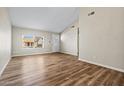 Spacious living room featuring wood-look floors and a large picture window at 5127 W Willow Ave, Glendale, AZ 85304