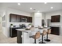 Contemporary kitchen boasts an island with bar stools and stainless steel appliances at 5751 E Axle Ln, San Tan Valley, AZ 85140