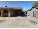 View of the long carport with concrete flooring and supports, leading to the backyard at 6226 W Coronado Rd, Phoenix, AZ 85035