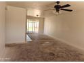 A spacious living room featuring a ceiling fan and sliding glass doors to the backyard at 6226 W Coronado Rd, Phoenix, AZ 85035