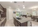 Open-concept kitchen with granite counters, island seating, and views of the living and dining areas at 686 N 152Nd Dr, Goodyear, AZ 85338