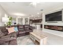 Inviting living room boasts an electric fireplace, large-screen TV, and seamless flow into the kitchen and dining area at 686 N 152Nd Dr, Goodyear, AZ 85338
