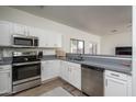 This kitchen features stainless steel appliances, modern cabinetry, and laminate flooring at 7028 W Lincoln St, Peoria, AZ 85345
