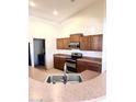 Bright kitchen with wood cabinets, stainless steel appliances, and a convenient breakfast bar overlooking the adjoining living area at 7310 W Pioneer St, Phoenix, AZ 85043