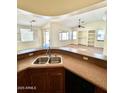 Open kitchen with breakfast bar offering views into the living room, creating a seamless space for entertaining and everyday living at 7310 W Pioneer St, Phoenix, AZ 85043