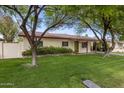 Exterior of charming single-story home featuring a well-manicured lawn and a welcoming green front door at 7608 E Avalon Dr, Scottsdale, AZ 85251