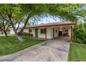 Single-story home featuring a well-manicured lawn, covered carport, and a welcoming green front door at 7608 E Avalon Dr, Scottsdale, AZ 85251