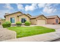 Attractive one-story home with desert landscaping, green lawn, and attached two-car garage at 8531 E Natal Cir, Mesa, AZ 85209