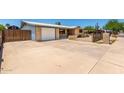 Single story home showing driveway, garage, brick accents and secure fencing at 900 S Palo Verde Dr, Apache Junction, AZ 85120