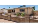 A single story brick home with a secure fenced yard and desert landscaping at 900 S Palo Verde Dr, Apache Junction, AZ 85120
