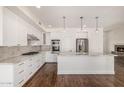 Well-lit kitchen with white cabinets, marble countertops, and stainless steel appliances at 122 W Cottage Ln, Tempe, AZ 85282