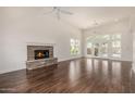 Spacious living room featuring hardwood floors, a stone fireplace, and plenty of natural light at 122 W Cottage Ln, Tempe, AZ 85282