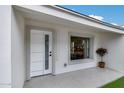 Charming front entrance featuring a modern door, window, and a decorative potted plant, all set against a bright white facade at 2236 N 22Nd St, Phoenix, AZ 85006