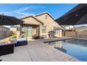 Inviting backyard featuring a pool, patio with outdoor furniture, and a built-in grill, perfect for entertaining at 26232 N 121St Ln, Peoria, AZ 85383