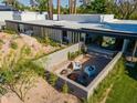 A landscaped backyard patio with an outdoor fire pit offers a charming seating area perfect for relaxation at 5311 E Mitchell Dr, Phoenix, AZ 85018