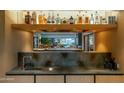 A kitchen bar features dark countertops and a wood backsplash, complemented by a view to a backyard patio at 5311 E Mitchell Dr, Phoenix, AZ 85018