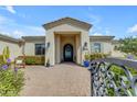 Inviting covered front door, featuring desert landscaping and a stylish, wrought-iron gate at 5586 W Rock Ct, San Tan Valley, AZ 85144