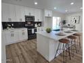 Modern kitchen with an island, stainless steel appliances, and white cabinetry at 6607 S Mitchell Dr, Tempe, AZ 85283
