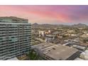 High-rise community with a view of the city and desert mountains in the background at sunset at 1 E Lexington Ave # 1302, Phoenix, AZ 85012