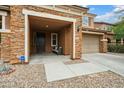 Inviting entryway with a covered porch, stone accents, and a well-manicured front yard with desert landscaping at 12172 W Davis Ln, Avondale, AZ 85323