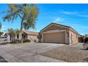 Single-story home with neutral exterior, two-car garage, tidy landscaping and spacious driveway at 12469 W Hearn Rd, El Mirage, AZ 85335