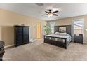 Serene main bedroom featuring neutral walls, carpet floors, a ceiling fan, and plenty of natural light at 13806 W Remuda Dr, Peoria, AZ 85383