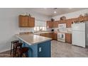 Well-lit kitchen featuring a breakfast bar and white appliances at 15246 N 138Th Ln, Surprise, AZ 85379