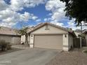 Charming single-story home featuring a neutral color palette, a two-car garage and minimal landscaping at 1704 E Redfield Rd, Gilbert, AZ 85234